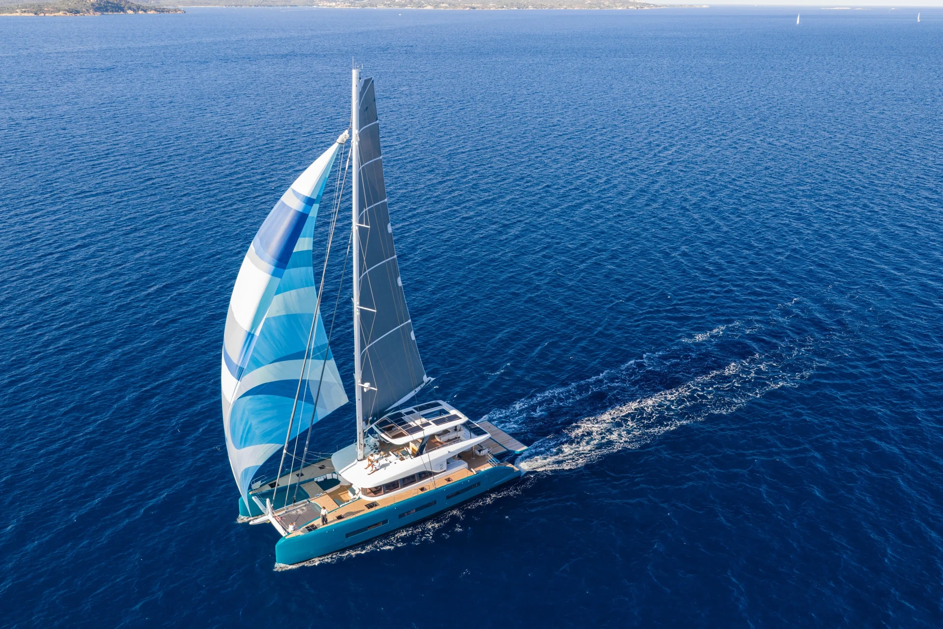 Aerial view of the Lagoon Eigthy2 catamaran under full sail across the open ocean