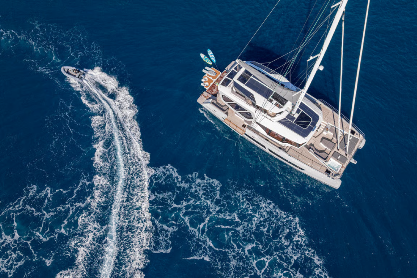 Aerial view of the Fountaine Pajot Thira 80 catamaran cruising under full sail across the open ocean