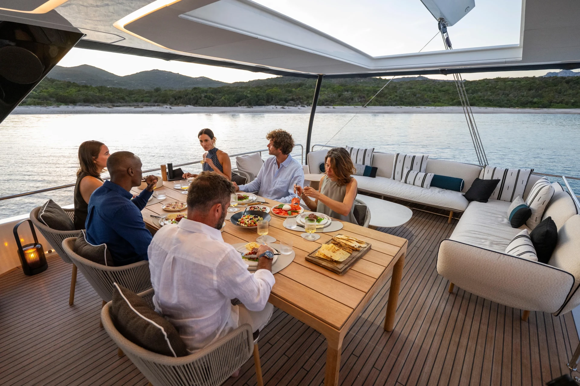 Guests dining together at sunset in the aft cockpit of the Lagoon Eigthy2